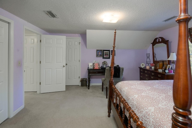 carpeted bedroom featuring a textured ceiling and vaulted ceiling