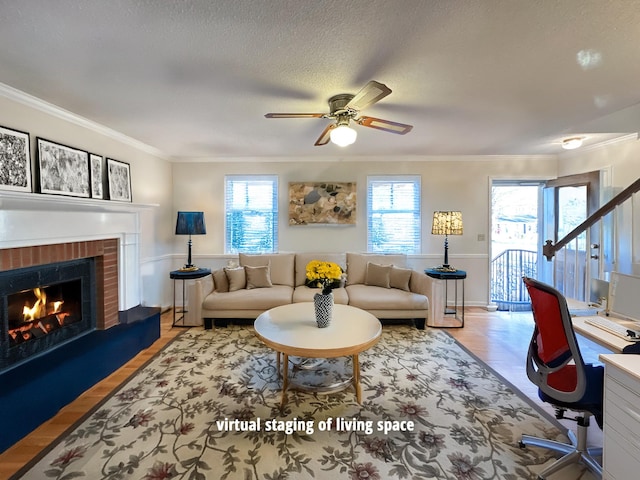 living room with ceiling fan, a textured ceiling, ornamental molding, and a fireplace