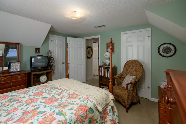 carpeted bedroom featuring vaulted ceiling and a textured ceiling