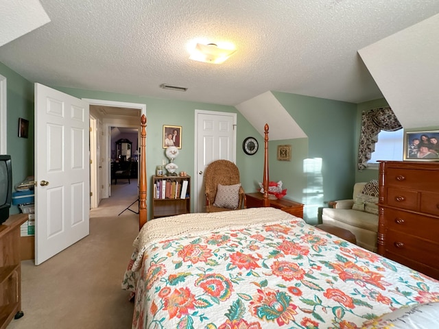 bedroom featuring a textured ceiling and light colored carpet