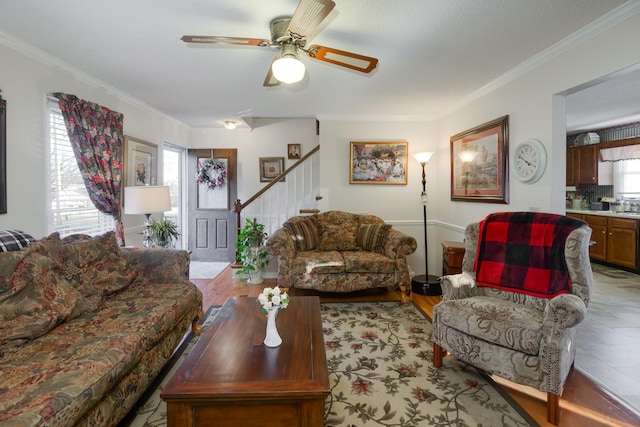 living room with crown molding, light hardwood / wood-style flooring, and ceiling fan