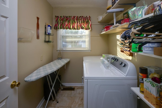 washroom with a textured ceiling and washing machine and dryer