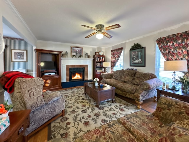 living room featuring a fireplace, light wood-type flooring, ceiling fan, and ornamental molding