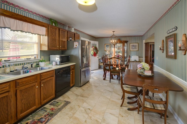 kitchen featuring pendant lighting, a textured ceiling, stainless steel appliances, sink, and ornamental molding