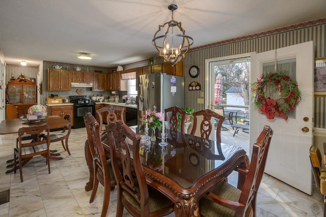 dining area with sink, a textured ceiling, and a notable chandelier