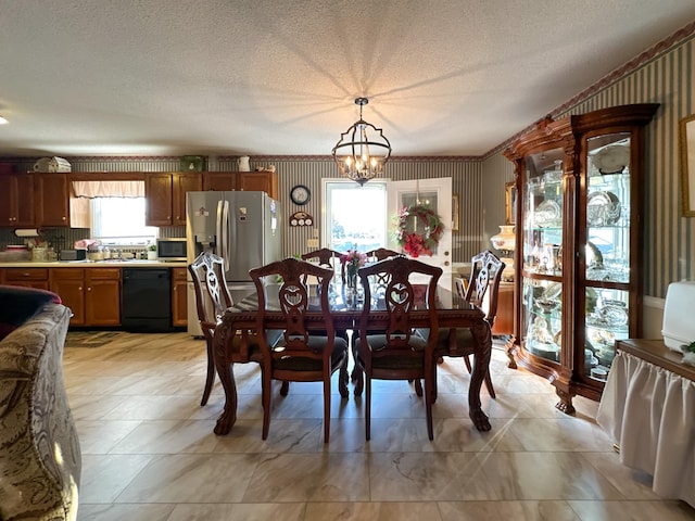 dining space featuring plenty of natural light, a textured ceiling, and an inviting chandelier