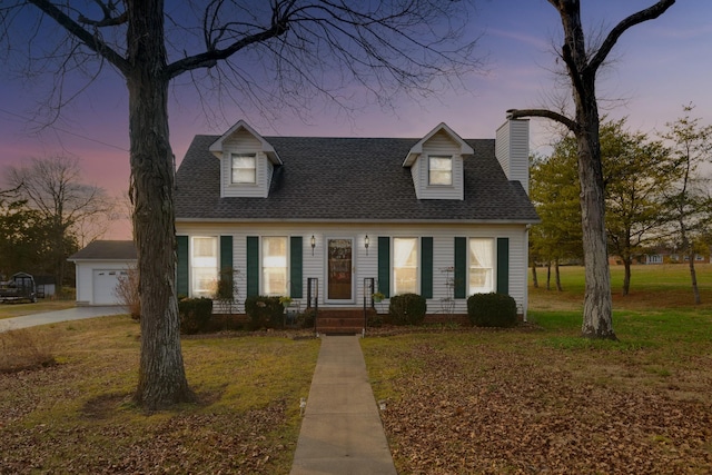 cape cod house with a garage and a yard