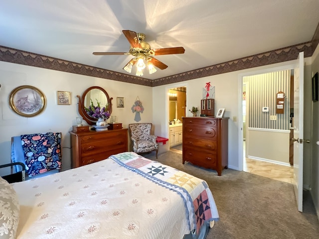 carpeted bedroom with ceiling fan and ensuite bath