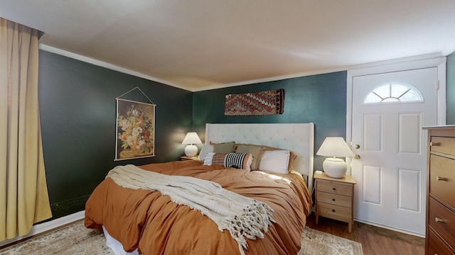 bedroom with ornamental molding and wood-type flooring