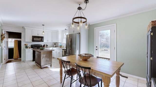 dining space featuring light tile patterned floors and ornamental molding