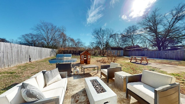 view of patio featuring an outdoor living space with a fire pit and a shed