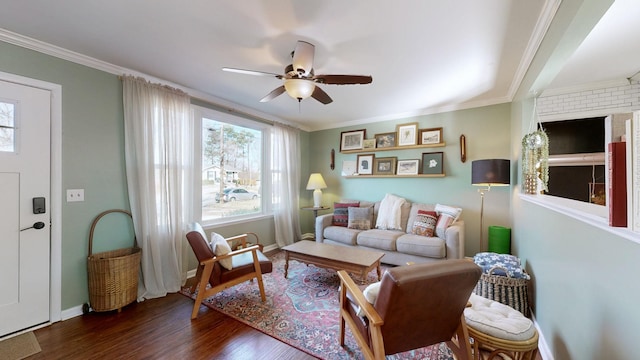 living room featuring dark wood-type flooring, ornamental molding, and ceiling fan