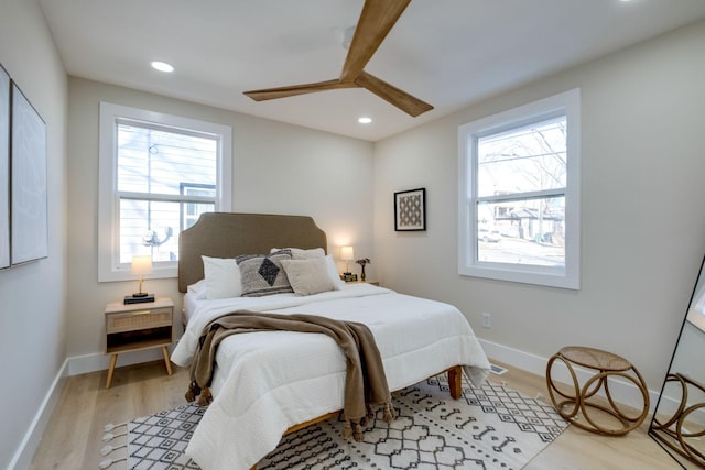 bedroom with ceiling fan, light wood-type flooring, and multiple windows