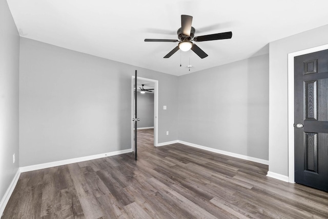 spare room with dark wood-type flooring and ceiling fan