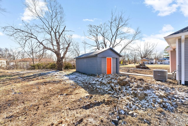 view of yard with central AC and a storage shed