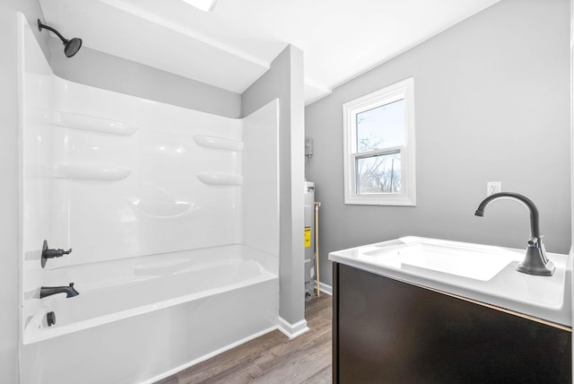 bathroom with hardwood / wood-style flooring, shower / bathing tub combination, vanity, and water heater