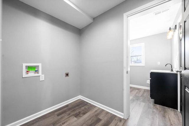 clothes washing area with sink, hardwood / wood-style floors, hookup for a washing machine, and electric dryer hookup