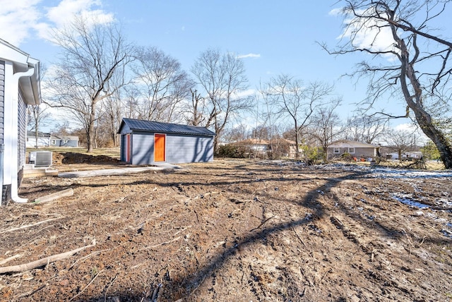 view of yard featuring central air condition unit and a storage shed