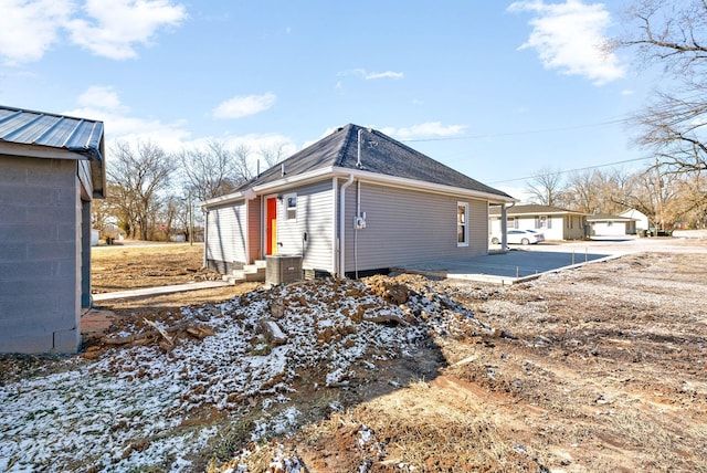 view of side of property featuring central AC unit and a patio