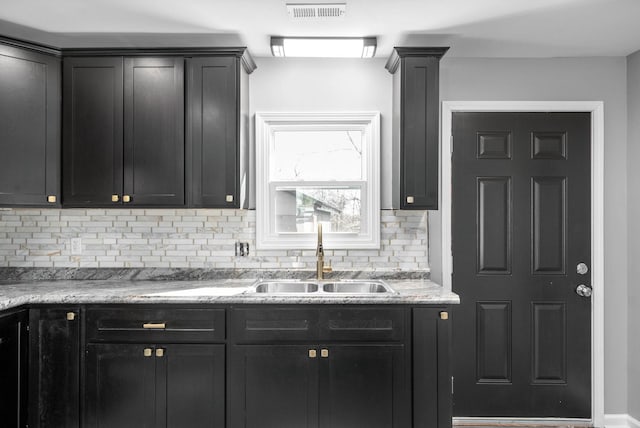 kitchen featuring decorative backsplash, sink, and ornate columns