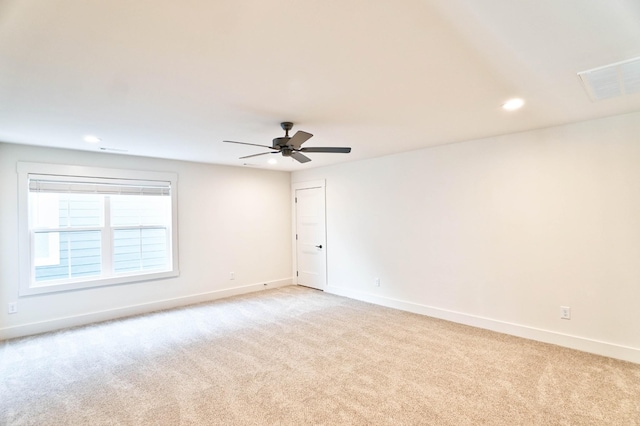 carpeted spare room featuring ceiling fan