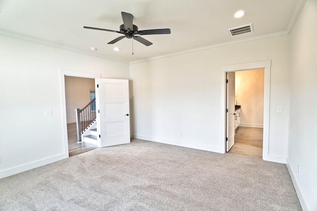 carpeted empty room featuring ceiling fan and ornamental molding