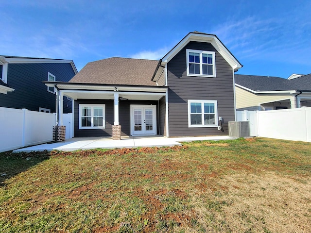 rear view of property with central AC unit, a patio area, french doors, and a yard