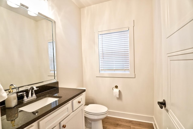 bathroom featuring toilet, vanity, and hardwood / wood-style floors