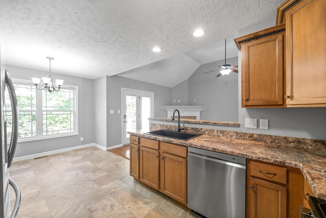 kitchen featuring lofted ceiling, sink, appliances with stainless steel finishes, a textured ceiling, and ceiling fan with notable chandelier