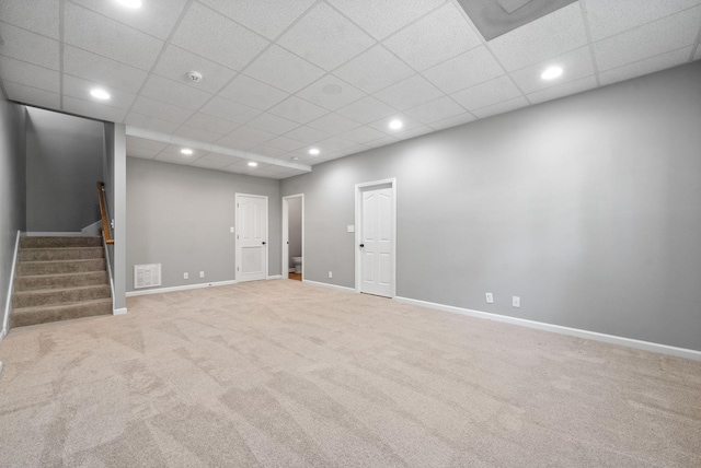 basement with light carpet and a paneled ceiling