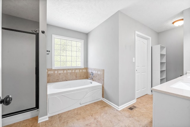 bathroom with a textured ceiling, separate shower and tub, and vanity