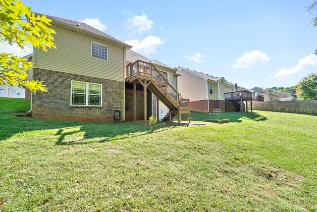 rear view of house with a deck and a lawn