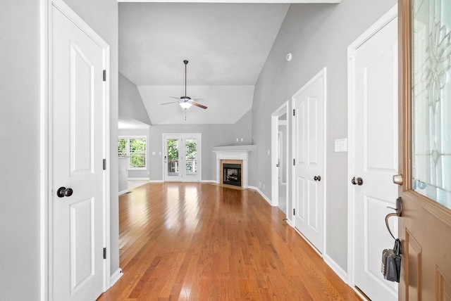 unfurnished living room with vaulted ceiling, ceiling fan, and light hardwood / wood-style floors