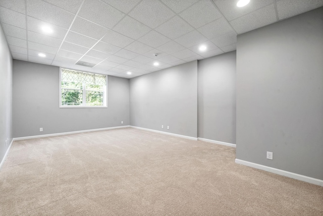 empty room featuring a paneled ceiling and carpet flooring