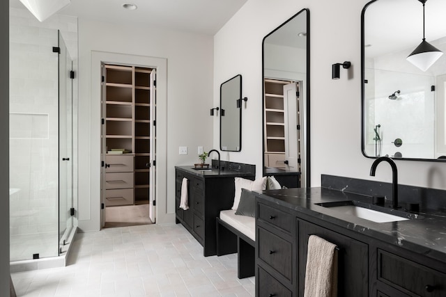 bathroom featuring a shower with shower door and vanity