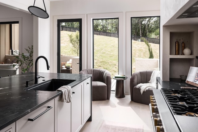 kitchen with white cabinets, plenty of natural light, sink, and pendant lighting