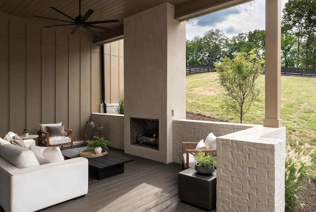 exterior space with ceiling fan and a large fireplace