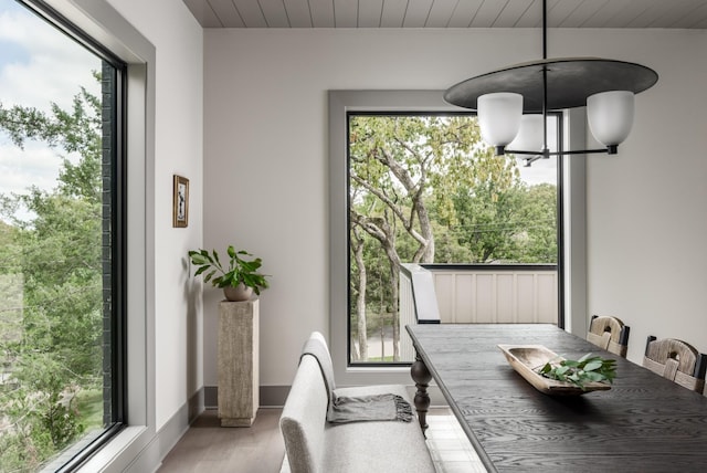 dining space featuring light wood-type flooring, plenty of natural light, and a notable chandelier