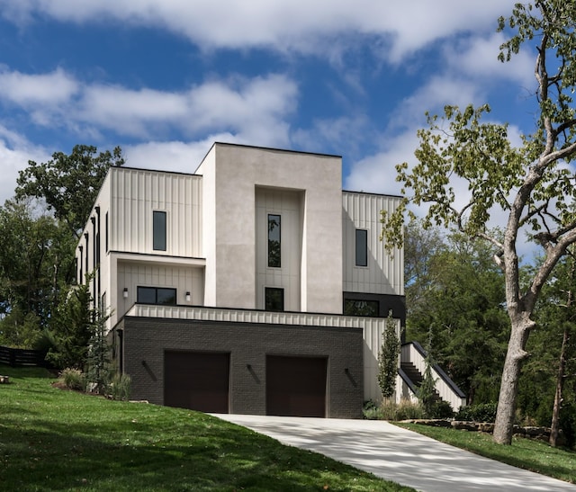 contemporary house with a front yard and a garage