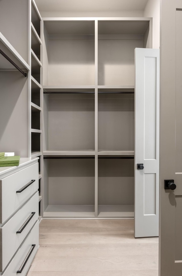 walk in closet with light hardwood / wood-style flooring