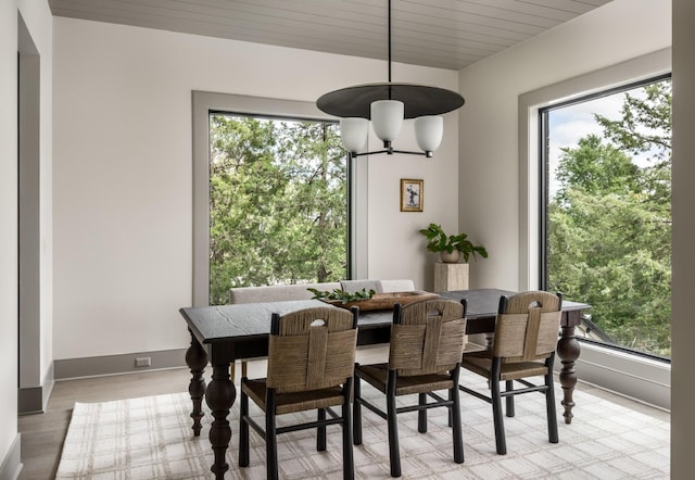 dining room featuring a notable chandelier, wood ceiling, and light hardwood / wood-style flooring