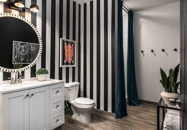 bathroom with toilet, wood-type flooring, and vanity