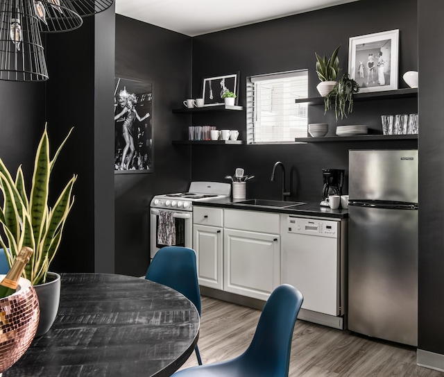 kitchen featuring light hardwood / wood-style floors, sink, white appliances, and white cabinets