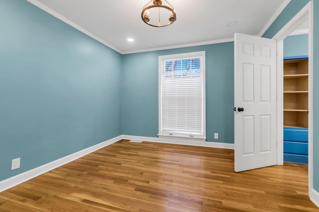 empty room with ornamental molding and light hardwood / wood-style flooring