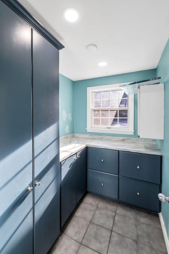 kitchen with light tile patterned floors, a barn door, and blue cabinetry