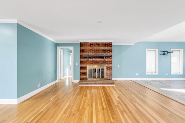 unfurnished living room featuring light wood-type flooring, ornamental molding, and a fireplace