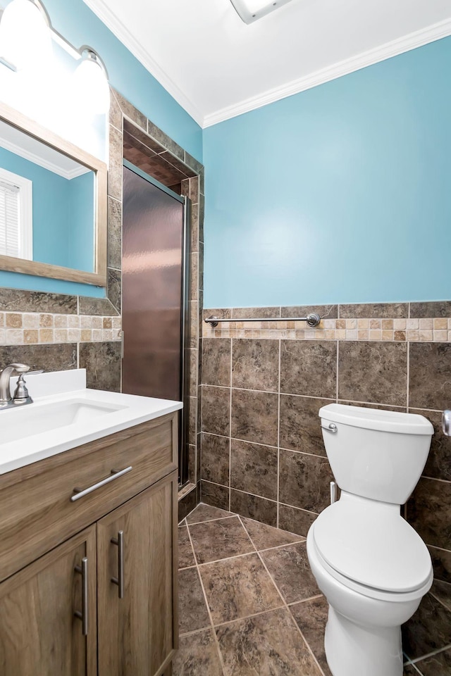 bathroom with toilet, crown molding, tile walls, and vanity