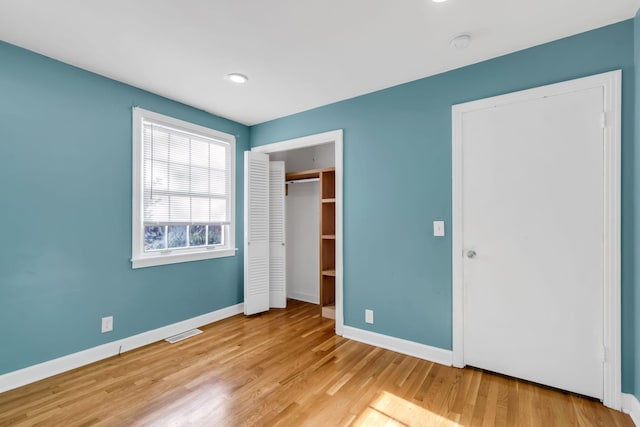 unfurnished bedroom with a closet and light hardwood / wood-style flooring