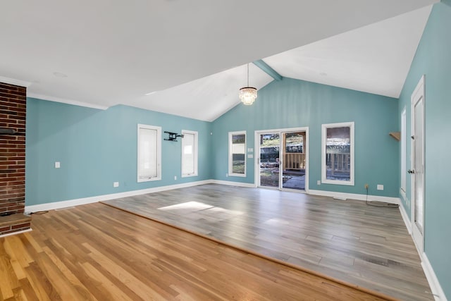 unfurnished living room with vaulted ceiling with beams, a chandelier, and wood-type flooring