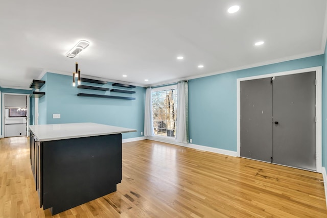 kitchen featuring a kitchen island, crown molding, and light hardwood / wood-style floors